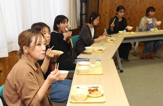 給食を試食する６年生の保護者ら＝神崎小学校