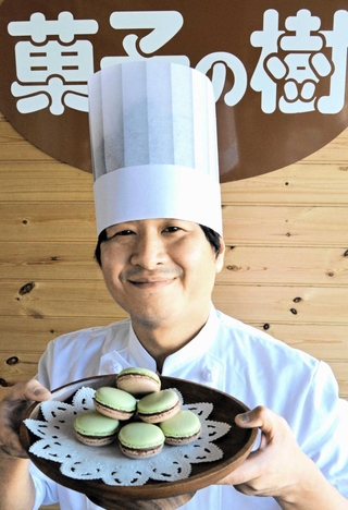 グランプリに輝いた「西はりま山椒とミルクチョコのマカロン」を手にする井口正登さん＝太子町東保、菓子の樹