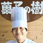 グランプリに輝いた「西はりま山椒とミルクチョコのマカロン」を手にする井口正登さん＝太子町東保、菓子の樹