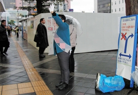 明石駅南側に立つ候補者。東側ロータリーは工事用フェンスで囲まれている＝大明石町１