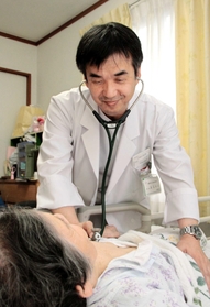患者宅で診察する豊岡市立森本診療所長の赤丸悟志さん＝豊岡市竹野町三原