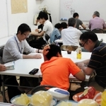 ボランティアから勉強を教わる中学生。寄付による軽食も用意されている＝神戸市内