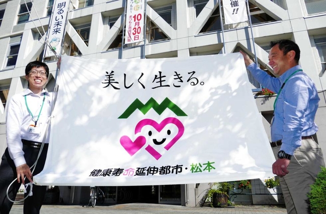松本市が市役所正面玄関の掲揚台に掲げる「健康寿命延伸都市」の旗。ワンフレーズで独自性を打ち出す＝長野県松本市