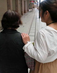 ケアマネジャーの女性と歩く認知症の女性＝神戸市内