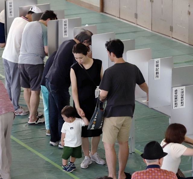 投票用紙に記入する有権者たち＝２１日午前、神戸市中央区港島中町３、港島学園（撮影・吉田敦史）