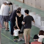 投票用紙に記入する有権者たち＝２１日午前、神戸市中央区港島中町３、港島学園（撮影・吉田敦史）