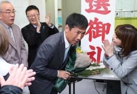 支持者から花束を受け取り、頭を下げる川部宣宏氏＝７日午後１１時半、神戸市長田区蓮宮通３（撮影・辰巳直之）