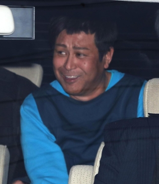 京都府警南署から警察車両で移送される朝比奈久徳容疑者＝２９日午後４時２３分、京都市南区（京都新聞撮影）