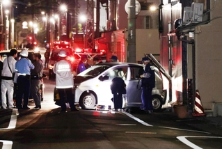 建物に突っ込んだとみられる車を調べる捜査関係者ら＝６日午後１１時３分、神戸市長田区五番町