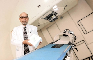 「保険適用の拡大で、粒子線治療の可能性も広がった」と語る兵庫県立粒子線医療センターの沖本智昭院長。手にするのは患者を固定する専用器具＝たつの市新宮町光都１