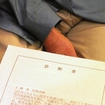 「闘病生活に入ってから、体に負担がかからないよう、好きなお酒をやめて規則正しい食生活を送っている」と診断書を示しながら話す男性＝神戸市内