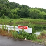 穂坂修ちゃんの遺体が見つかった現場周辺。ため池近くの草陰に、花束と菓子が置かれていた＝２６日、神戸市西区平野町慶明