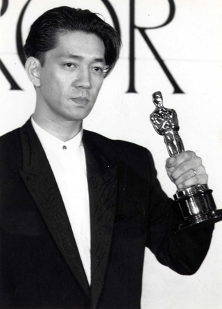 第６０回アカデミー賞作曲賞を受賞し帰国会見でオスカー像を披露する坂本龍一＝１９８８年４月２５日