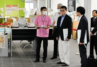 マイナンバーカードの申請、交付を行う窓口を視察する河野太郎デジタル相（右から３人目）＝９日、洲本市役所