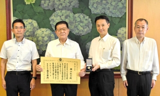 兵庫県警の村井紀之本部長（右から２人目）から警察協力章の伝達を受けた横山弘介さん（同３人目）＝県警本部