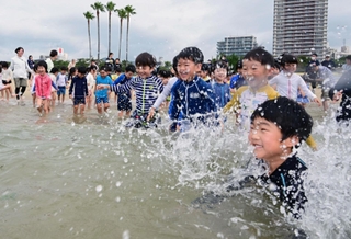 元気よく海に入る幼稚園児ら＝１３日午前、神戸市須磨区、須磨海水浴場（撮影・斎藤雅志）