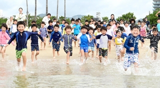 元気よく海に入る幼稚園児ら＝１３日午前、神戸市須磨区、須磨海水浴場（撮影・斎藤雅志）
