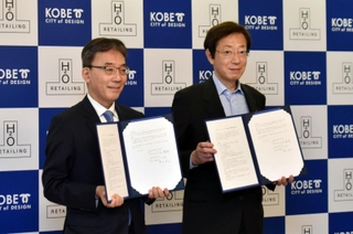 包括連携の協定書を手にするエイチ・ツー・オーリテイリングの荒木直也社長（左）と神戸市の久元喜造市長＝神戸市役所