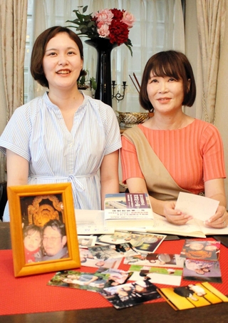 家族写真を見ながら吉田保之さんについて語る妻拓子さん（右）と長女理恵さん＝神戸市東灘区