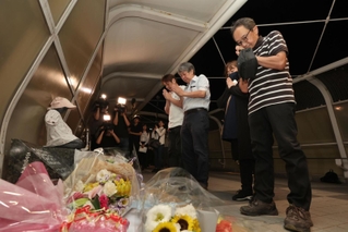 慰霊碑に手を合わせる事故の遺族＝２１日夜、明石市大蔵海岸通１（撮影・小林良多）