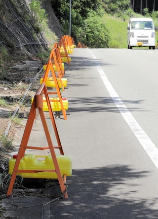 グレーチングが多数盗まれた市道。道沿いにオレンジのバリケードが続く＝丹波市山南町金屋
