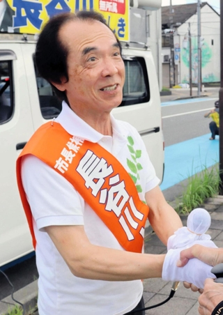巡回中、支援者に声をかけられ握手する長谷川美樹氏＝三田市三田町