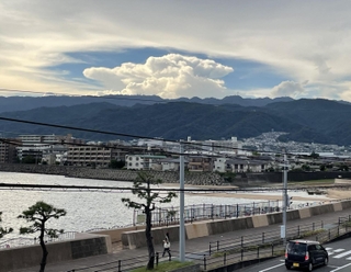 六甲山系の山々と住宅街の上空に広がった巨大な雲＝２６日午後、芦屋市内（撮影・三浦拓也）