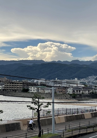 六甲山系の山々と住宅街の上空に広がった巨大な雲＝２６日午後、芦屋市内（撮影・三浦拓也）