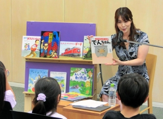 「防災１００年えほんガーデン」の催しで、子どもたちに絵本を読み聞かせる古賀涼子さん＝人と防災未来センター