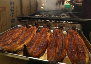 たれを絡めて香ばしく焼き上げられるウナギ＝２９日午後、明石市本町１