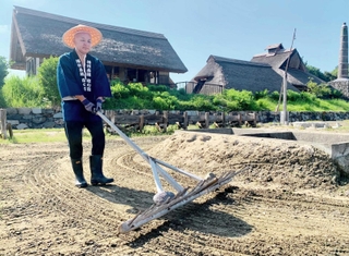「塩の国」の入浜塩田で砂をかきおこす作業。塩がついた砂は沼井（右）に入れ、濃い塩水をつくる＝赤穂市御崎、兵庫県立赤穂海浜公園
