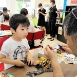 トヨタ車の販売店内でミニ四駆作りをする親子＝三田市すずかけ台３、ネッツテラス新三田