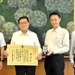 兵庫県警の村井紀之本部長（右から２人目）から警察協力章の伝達を受けた横山弘介さん（同３人目）＝県警本部