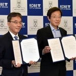 包括連携の協定書を手にするエイチ・ツー・オーリテイリングの荒木直也社長（左）と神戸市の久元喜造市長＝神戸市役所