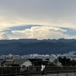 六甲山系の山々と住宅街の上空に広がった巨大な雲＝２６日午後、芦屋市内（撮影・三浦拓也）