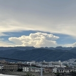 六甲山系の山々と住宅街の上空に広がった巨大な雲＝２６日午後、芦屋市内（撮影・三浦拓也）