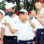 田植えの前に、自分の種もみから育てた苗を手に笑顔を見せる新宅佑輔君（中央）＝井吹東小学校