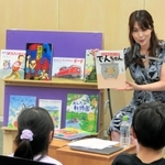 「防災１００年えほんガーデン」の催しで、子どもたちに絵本を読み聞かせる古賀涼子さん＝人と防災未来センター