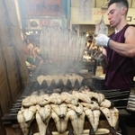 炭火で丹念に焼き上げられるウナギ。仕上がったそばから客が買い求めた＝２９日午後、明石市本町１