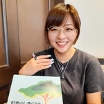 ファシリテーター向け冊子「虹色のしずくたち」を持つ森田望奈未さん。表紙のデザインを手がけた＝神戸市中央区