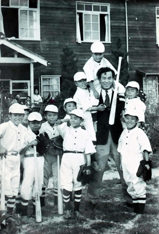 信愛学園で野球に熱中した内藤博一さん（左から３番目）。慰問に訪れた阪神の投手兼監督、若林忠志さんと＝神戸市内