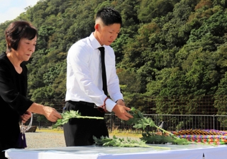 犠牲者を悼み献花する遺族＝９日午前、佐用町久崎