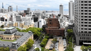 ２０年以上にわたって暫定利用が続くコインパーキング（写真中央）。神戸・元町の一等地にある＝神戸市中央区下山手通５から