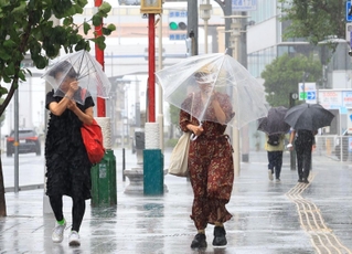 猛烈な風雨の中、傘を差して歩く人たち＝１５日午前９時４４分、神戸市中央区（撮影・鈴木雅之）