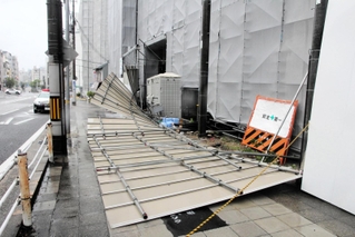 工事現場を囲っていたパネルが強風で倒れ、約１０メートルにわたって歩道をふさいだ＝１５日午前８時２９分、神戸市兵庫区荒田町１