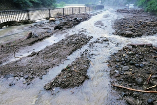 矢田川の氾濫や山からの土砂流入で冠水した県道香住村岡線＝１５日午後５時２４分、兵庫県香美町村岡区高津（撮影・長谷部崇）