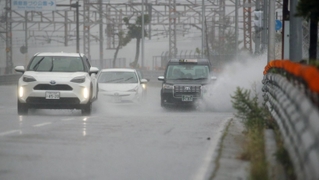 激しい雨が降り続く中、水しぶきを上げて走る車＝１５日午前１１時２６分、神戸市須磨区一ノ谷町５（撮影・小林良多）