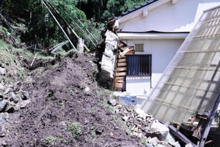 裏山から崩れた土砂や樹木が直撃した民家＝１６日午後、香美町村岡区和田