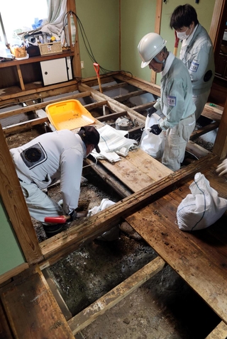 床下にたまった泥のかき出す人たち＝１８日、兵庫県香美町香住区間室