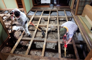 床下にたまった泥をかき出すボランティア＝１８日午前、兵庫県香美町香住区間室